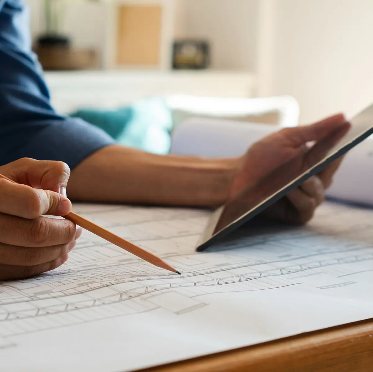 Architect reviewing blueprints and tablet
