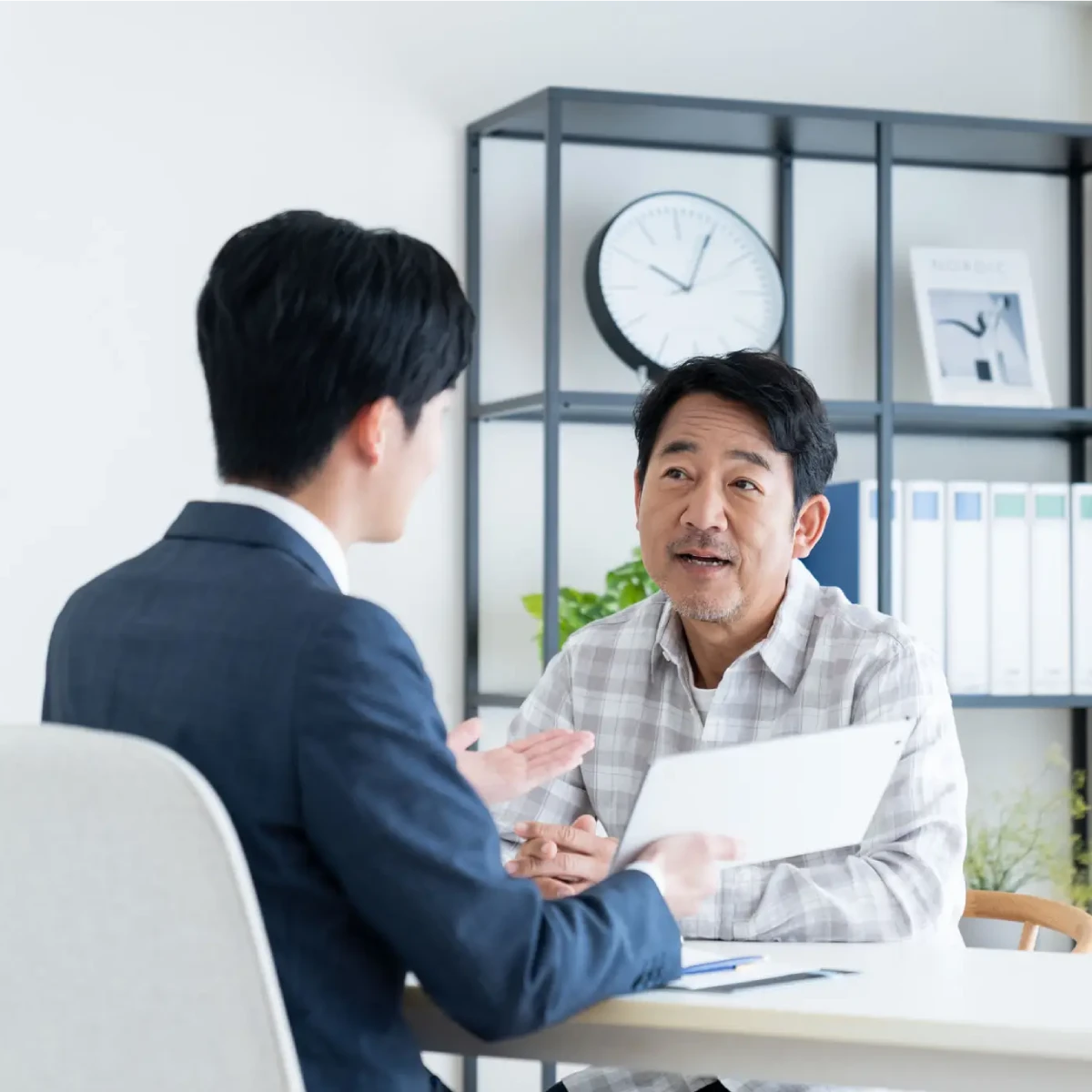Two men having a serious conversation in an office setting.