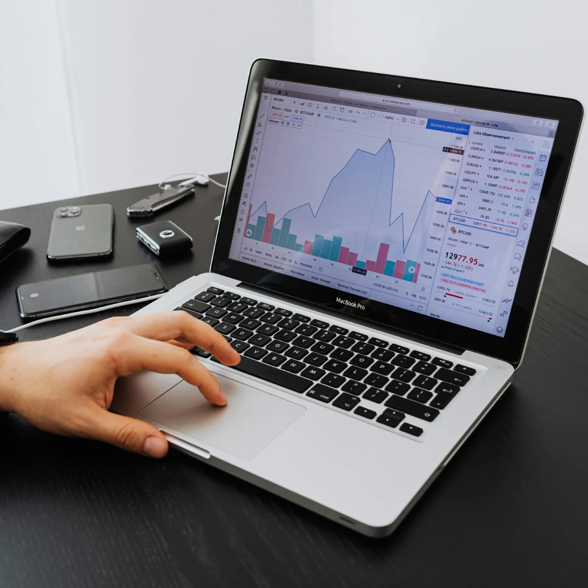 Person analyzing financial data on a laptop screen.
